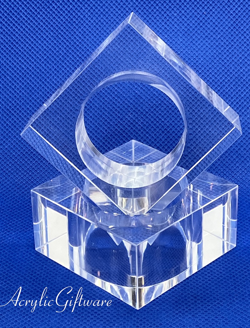 Clear acrylic sculpture featuring a circular and diamond shape, designed for decorative purposes on a blue background.
